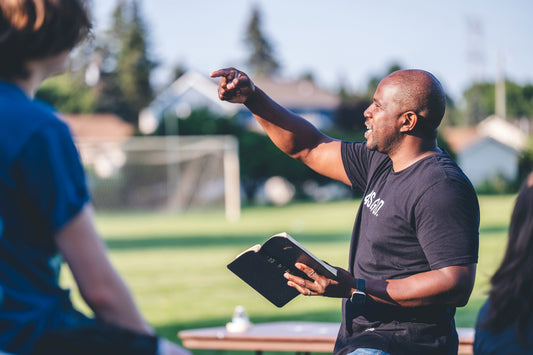 pastor speaking while holding Bible